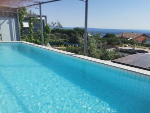 a large swimming pool with blue water in a house at Villa Suzi Donkey farm with seaview in Šmrika