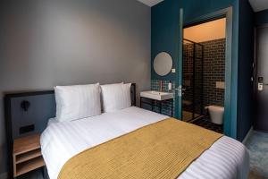 a bedroom with a large bed and a bathroom at FD Hotels in Rotterdam