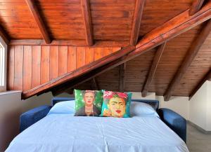 ein Bett mit zwei Kissen auf dem Dachboden in der Unterkunft La Rondinella - Loft with fantastic view on Lake Como in Argegno