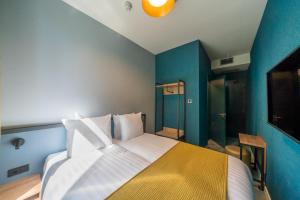 a bedroom with a large bed with a yellow and blue wall at FD Hotels in Rotterdam