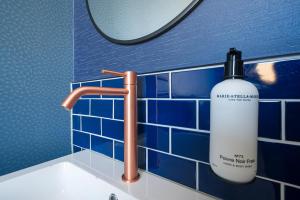 a bathroom sink with a bottle of mouthwash next to a mirror at FD Hotels in Rotterdam +23 photos