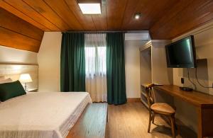 Uma TV ou centro de entretenimento em Hotel Fioreze Chalés