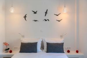 a bedroom with a bed with birds on the wall at Acropolis in Parikia