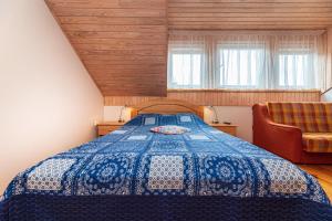 1 dormitorio con 1 cama azul y 1 silla en Vila Arona, en Palanga