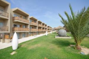 un complejo con una palmera y un edificio en Oasis Salinas Sea, en Santa Maria