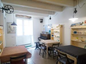 una cucina e una sala da pranzo con due tavoli e sedie di B&B Terra - Stanza Natura a Carloforte