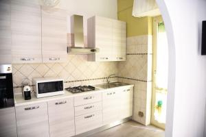 a kitchen with white cabinets and a microwave at Il Tempio di Vesta in Civitavecchia