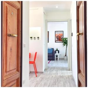 een open deur naar een woonkamer met een rode stoel bij PIGNETO VILLAGE Roma Guest House Apartment in Rome