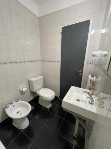 a bathroom with a toilet and a sink at Apart Bahia in Bahía Blanca