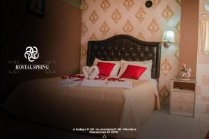 Hostal Spring في هانوكو: غرفة نوم بسرير كبير ومخدات حمراء