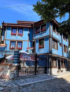 a blue building with flowers in the windows at PULPUDEVA Family Hotel in Plovdiv