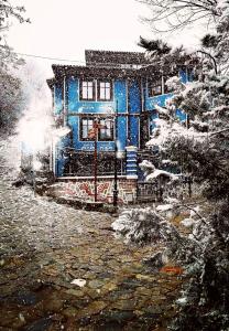 a painting of a blue house in the snow at PULPUDEVA Family Hotel in Plovdiv