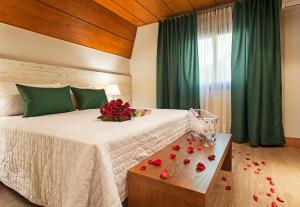 a bedroom with a bed with roses on a table at Hotel Fioreze Chalés in Gramado