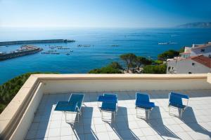 a pool with chairs and a view of the ocean at Albergo Miramare in Cala Gonone