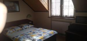 Wynajem Pokoi Osada في فواديسوافوفو: غرفة نوم صغيرة بها سرير ونافذتين