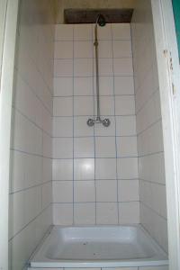 uma banheira na casa de banho com azulejos brancos em Bikers camp em Porec