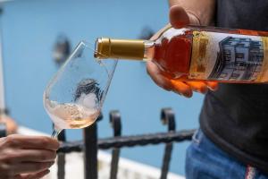 eine Person, die eine Flasche Wein in ein Glas gießt in der Unterkunft PULPUDEVA Family Hotel in Plowdiw