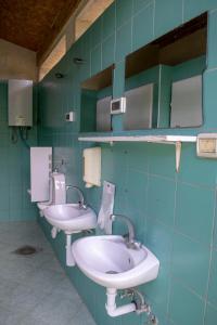 La salle de bains est pourvue de 2 lavabos et de 2 miroirs. dans l'établissement Bikers camp, à Poreč