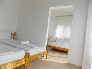 a bedroom with two beds and a mirror at Hotel Sgouridis in Limenaria