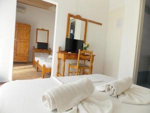 1 dormitorio con 1 cama con toallas en Hotel Sgouridis, en Limenaria