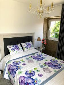 a bedroom with a bed with purple flowers on it at Casa Pedro e Inês in Viana do Castelo