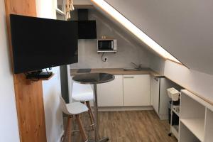 a small kitchen with a table and a flat screen tv at charmant studio bord de mer in Menton