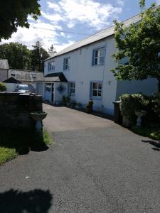 a white house with a driveway in front of it at Newby Cross in Carlisle