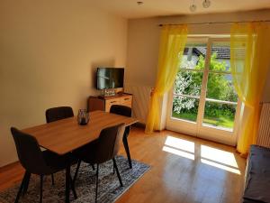 ein Esszimmer mit einem Tisch, einem TV und einem Fenster in der Unterkunft Ferienwohnung Berger in Gmünd in Kärnten