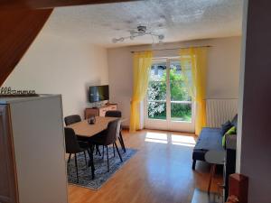 ein Wohnzimmer mit einem Tisch, Stühlen und einem Fenster in der Unterkunft Ferienwohnung Berger in Gmünd in Kärnten