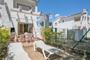 a patio with chairs and a table in front of a building at Rentalmar El Pinar Adosados in Miami Platja