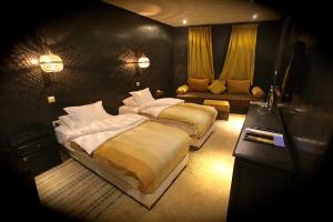 a bedroom with two beds and a couch at Riad Dar Haven in Tamraght Ou Fella +37 photos