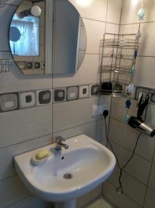 y baño con lavabo blanco y espejo. en Tumidaj Cottage, en Bogacko