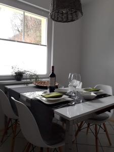 a dining room table with a bottle of wine and chairs at Apartement am Waldrand in Bad Wildbad