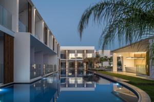 an exterior view of a building with a swimming pool at Sensus Experience by Lavris in Gouves