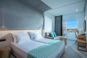 a bedroom with a large white bed and a balcony at Sensus Experience by Lavris in Gouves