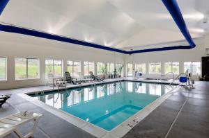 a large swimming pool with blue water in a building at Comfort Suites Abingdon I-81 in Abingdon