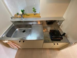 a stainless steel sink in a small kitchen at Downtown area Spacious cozy room Susukino IK501 in Sapporo +26 photos