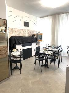 - une cuisine avec des tables et des chaises dans une pièce dans l'établissement Hotel Alessander, à Milan