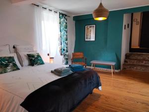 um quarto com uma cama grande e uma parede azul em Le clos de CINACLE em Ogeu-les-Bains