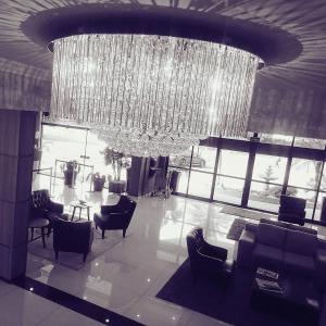 einen großen Kronleuchter in einer Lobby mit Stühlen und Tischen in der Unterkunft Hotel Cristal Rio Claro in Rio Claro