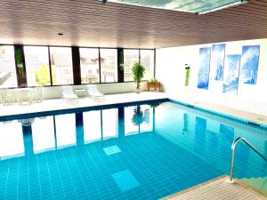 una gran piscina con sillas en un edificio en Gemütliche Ferienwohnungen mit Pool & Sauna, en Höchenschwand