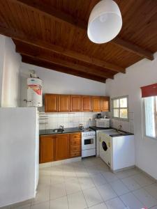 a kitchen with wooden cabinets and a white appliance at Apart Bahia in Bahía Blanca