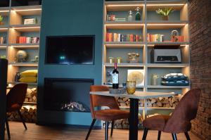 a dining room with a fireplace and a table and chairs at Hotel Rozenburg in Rozenburg