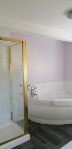 a white bathroom with a tub and a glass shower at Newby Cross in Carlisle