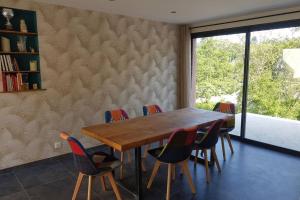 a dining room with a wooden table and chairs at VILLA Adrien , maison de charme. in Casanova +10 photos