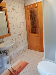 La salle de bains est pourvue de toilettes, d'un lavabo et d'une porte. dans l'établissement Počitniško stanovanje PLANJA, à Vallée de la Soča