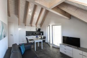 een woonkamer met een bank, een tafel en een tv bij Apartment Müller am See in Immenstaad am Bodensee