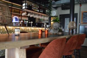 a bar in a restaurant with a wooden table and chairs at Hotel Rozenburg in Rozenburg