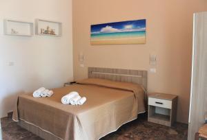 una camera da letto con un letto con asciugamani sopra di Dimora Rem Country Life a 2 minuti dal mare a Nardò