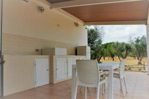un patio con tavolo e sedie su un patio di Dimora Rem Country Life a 2 minuti dal mare a Nardò